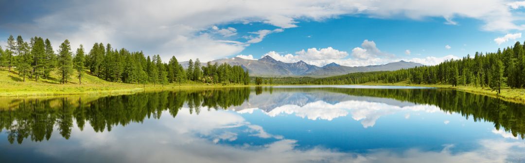 A calm lake surrounded by countryside with the sky reflecting in the water A calm lake surrounded by countryside with the sky reflecting in the water